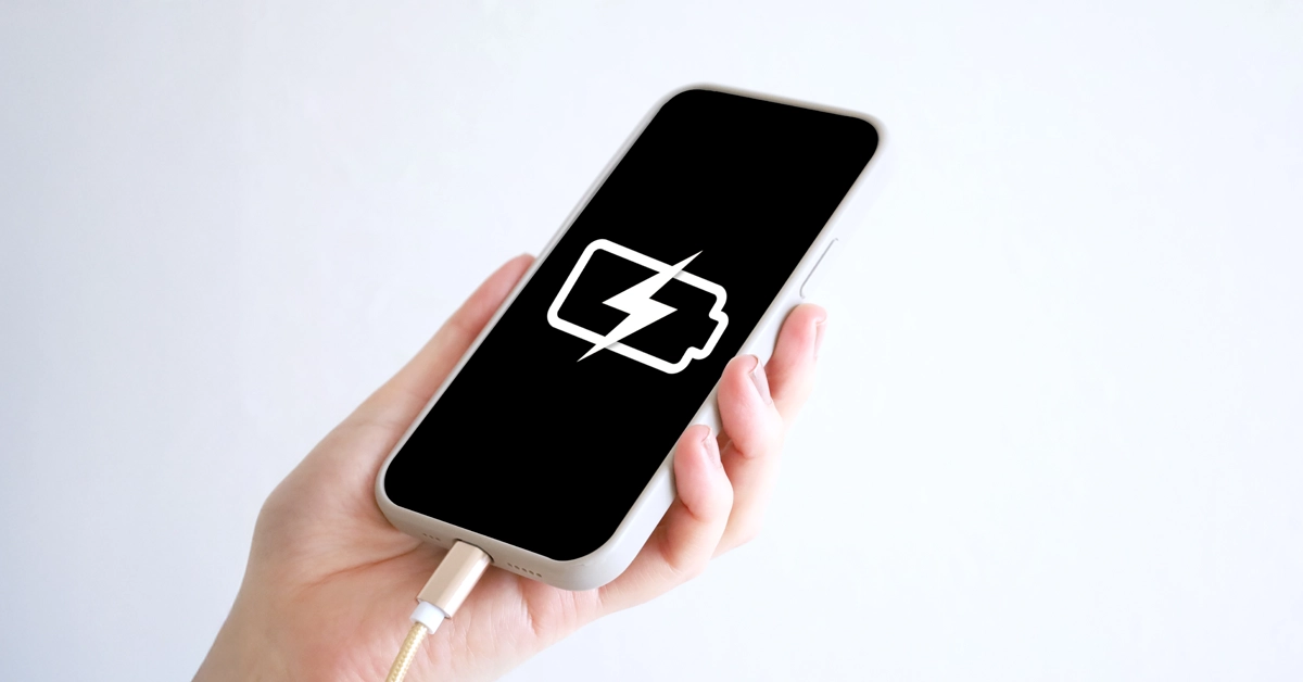 充電しているスマホを持っている画像