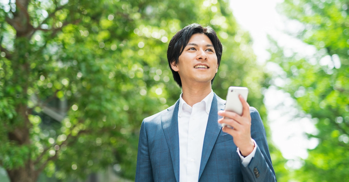 自然の中でスマホを持っている画像