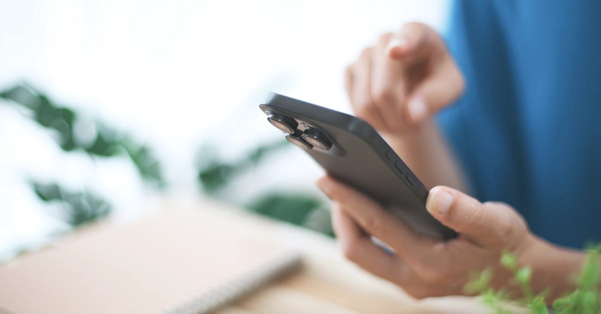 机の上でスマホを操作している画像