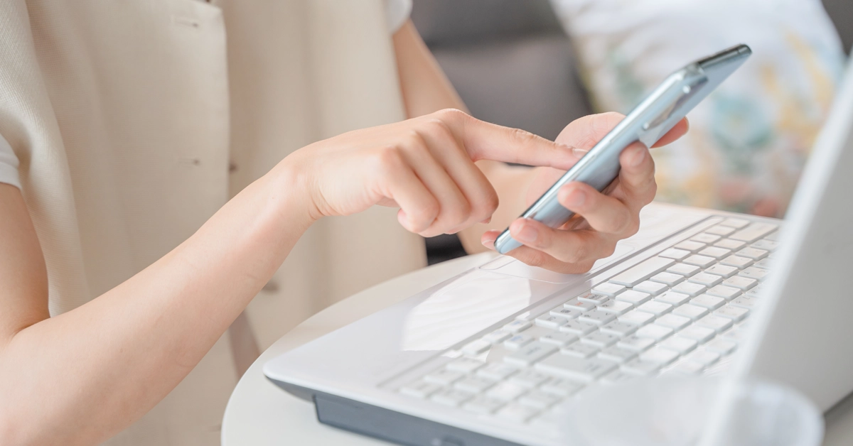 PC前でスマホを操作する画像