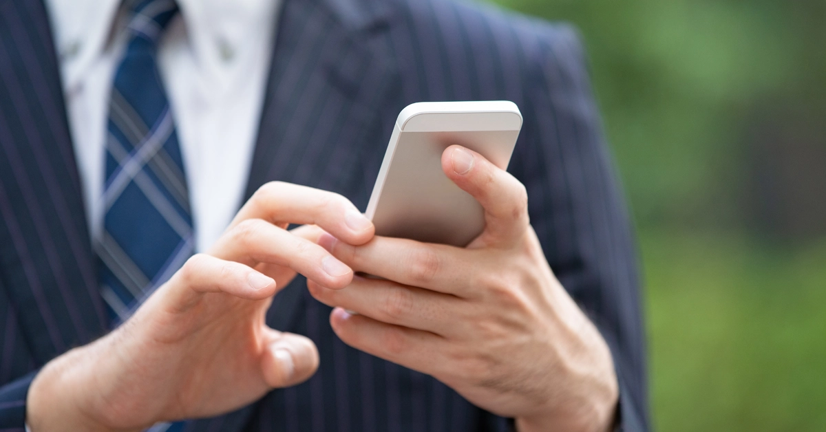 ビジネスマンがスマホを操作している画像