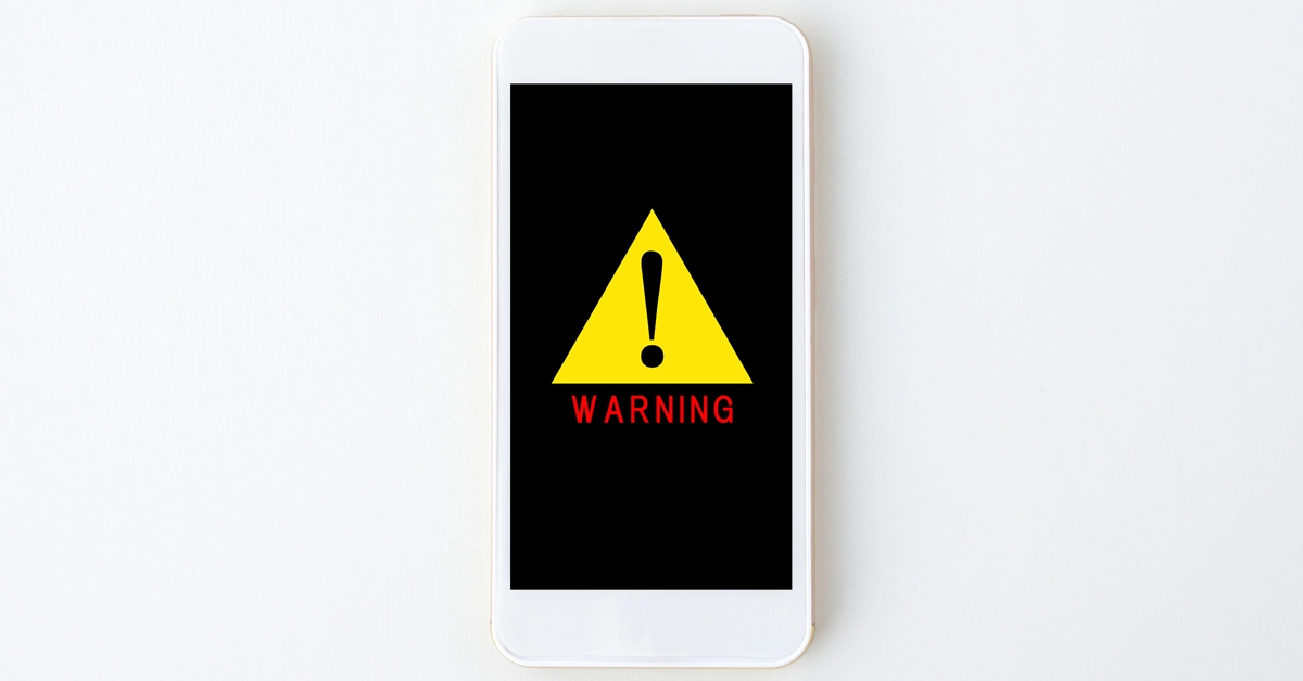 スマホに注意マークが表示されている画像