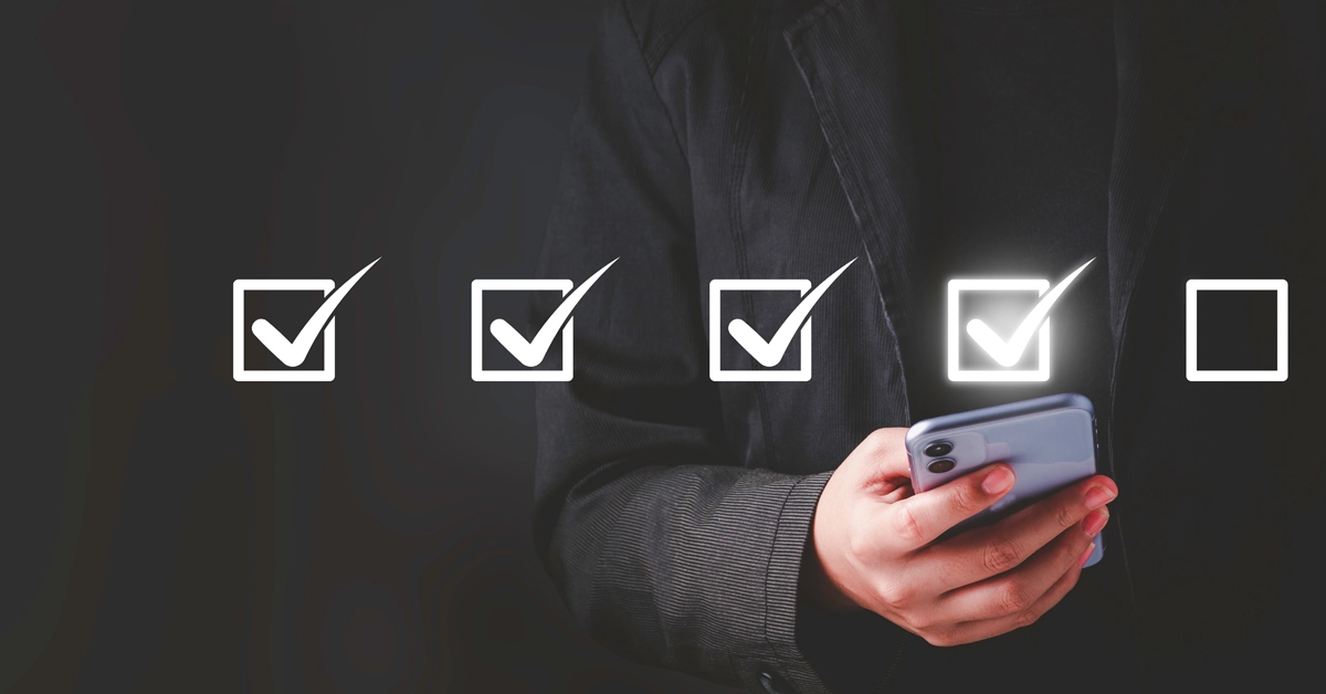 チェックリストのイメージとスマホを持っている男性の画像