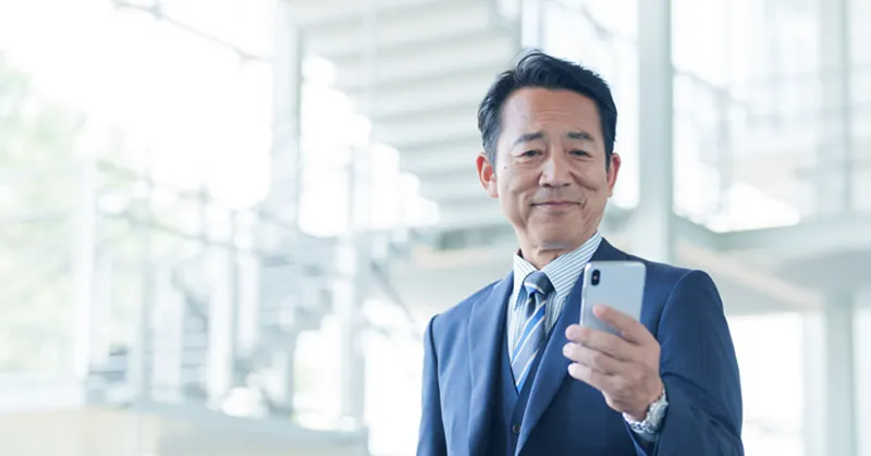 スマートフォンを持つ人の手元の画像